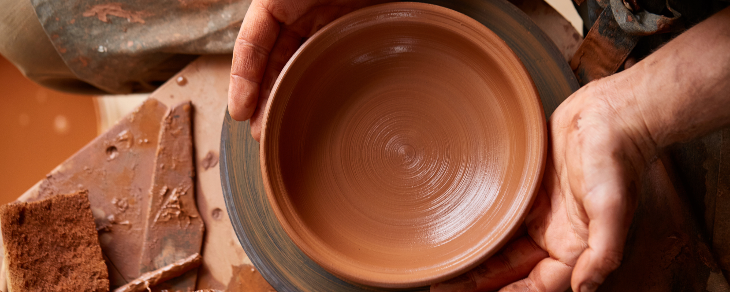 Red clay pottery being thrown on the potter's wheel